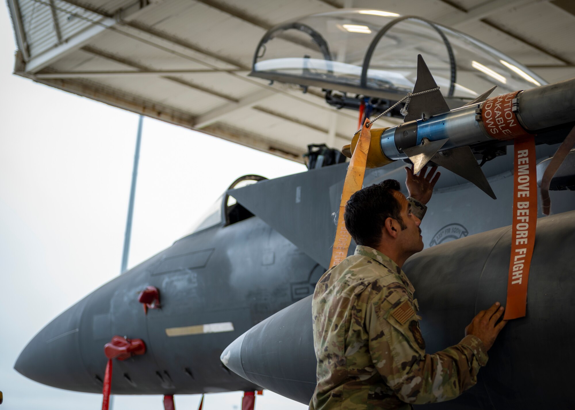 Airman 1st Class Carlos Santini, 333rd Fighter Generation Squadron load crew technician, inspects an AIM-9 Sidewinder missile mounted onto an F-15E Strike Eagle at Seymour Johnson Air Force Base, Oct. 12, 2021.