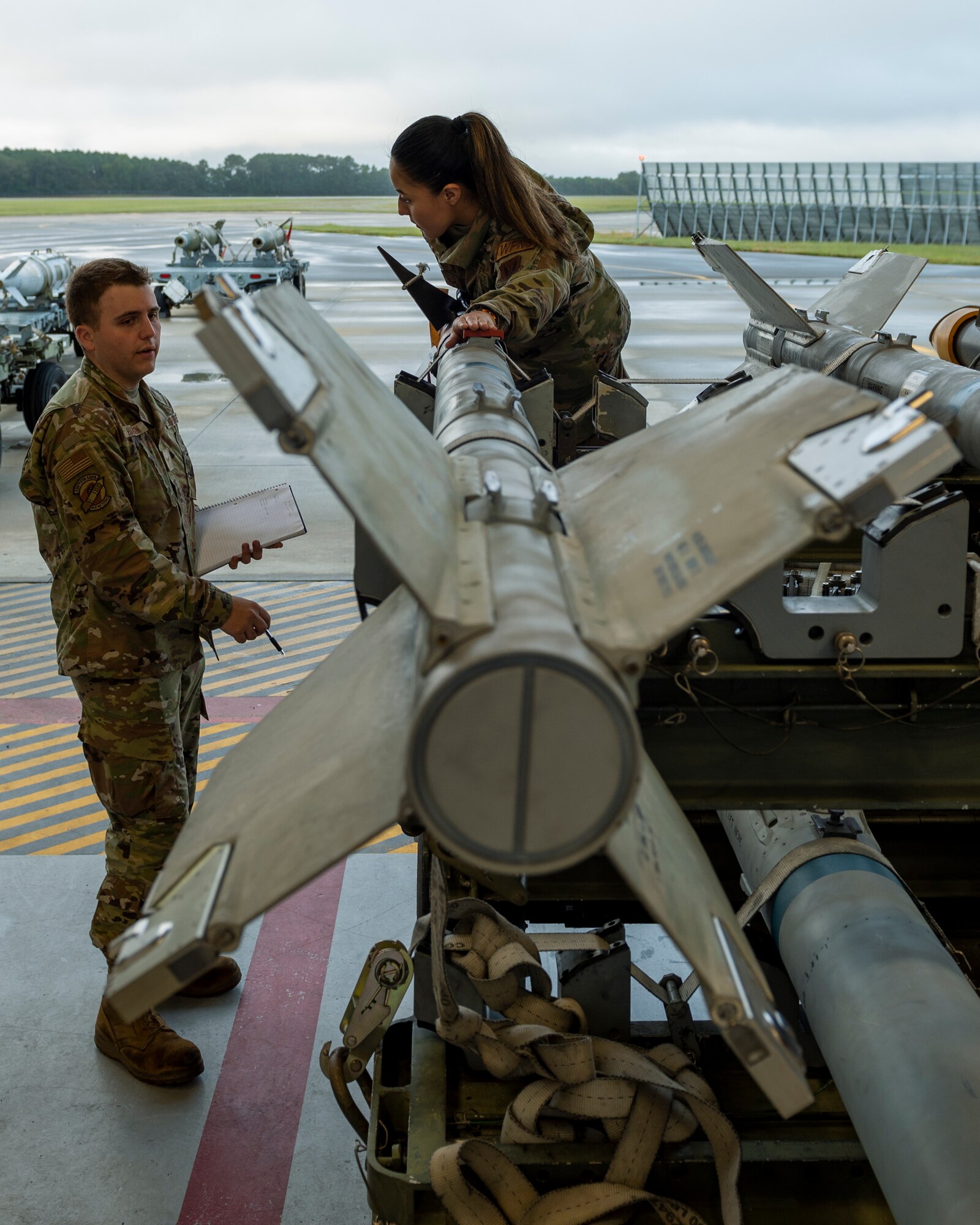 Senior Airman Angelica Diaz, center, Weapons Standardization Squadron lead crewmember, teaches Airman Zachary Harrison, 336th Fighter Generation Squadron load crew technician, about the AIM-9 Sidewinder missile at Seymour Johnson Air Force Base, North Carolina, Oct. 12, 2021.