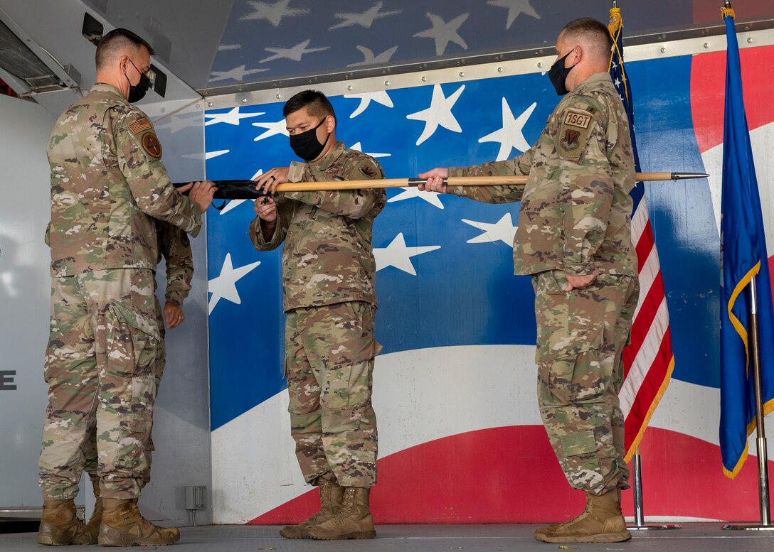 Maj. Christopher Crommie, center, former 704th Aircraft Maintenance Squadron commander, furls the 704th AMXS guidon at Seymour Johnson Air Force Base, North Carolina, Sept. 29, 2021.
