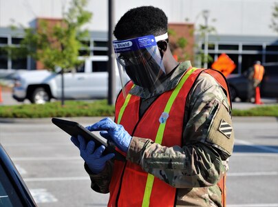 U.S. Army Spc. Rashad Kelley, a unit supply specialist with the Headquarters and Headquarters Battery, 1st Battalion, 118th Field Artillery Regiment, 48th Infantry Brigade Combat Team, Georgia Army National Guard, receives a visitor April 13, 2021, at a mass vaccination site in Savannah, Georgia. The Georgia National Guard provided on-site logistics and operation support to the Georgia Emergency Management and Homeland Security Agency as they administered COVID-19 vaccinations at mass vaccination locations across Georgia.