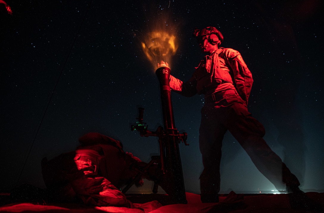 Marine Corps Lance Nathaniel Wesley, left, and Lance Cpl. Victor Pinto, mortarmen assigned to Charlie Company, Battalion Landing Team 1/1, 11th Marine Expeditionary Unit, fire an M252A2 81 mm mortar system during a night live-fire exercise at Camp Buehring, Kuwait, Oct. 3, 2021. The 11th MEU and Essex Amphibious Ready Group are deployed to the U.S. 5th Fleet area of operations in support of naval operations to ensure maritime stability and security in the Central Region, connecting the Mediterranean and Pacific through the Western Indian Ocean and three strategic choke points.