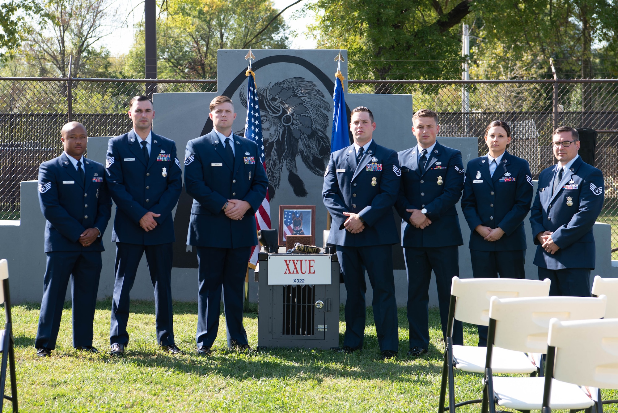 Airmen stand together in front of military working dog memorial.