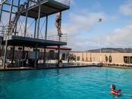 A U.S. Marine with 1st Battalion, 5th Marine Regiment, 1st Marine Division, jumps off the high dive during a swim qualification at Marine Corps Base Camp Pendleton, California, July 7, 2021. Marines are required to annually re-qualify, thus ensuring mission readiness, comfortability in the water and quick response time in the case of an aquatic accident. (U.S. Marine Corps photo by Cpl. Hannah Hall)