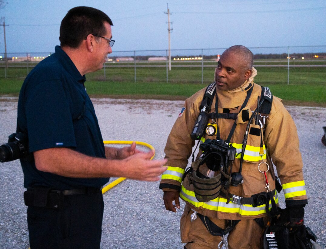 Chief Duane Stitzel (left), Dayton International Airport Fire Department, talks with Jerry Hopewell, 788th Civil Engineer Squadron Fire Department firefighter and emergency medical technician, on Oct. 5, 2021, after one of his crews extinguished a live training fire at Wright-Patterson Air Force Base, Ohio. Hopewell was among the Wright-Patt firefighters who monitored and advised DIA counterparts. (U.S. Air Force photo by R.J. Oriez)
