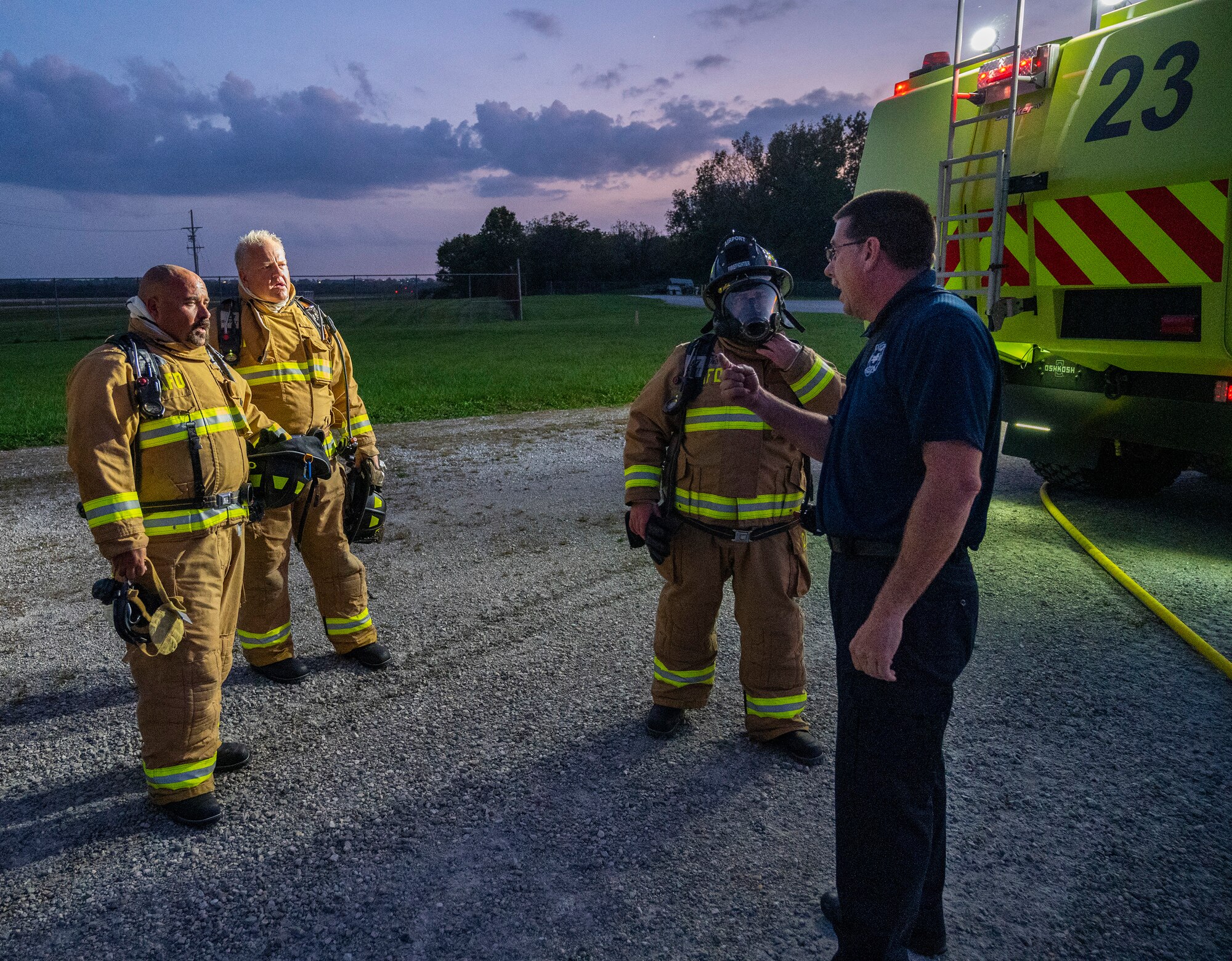 Dayton International Airport Fire Department Chief Duane Stitzel (right) talks with some of his firefighters Oct. 5, 2021, between live training fires at Wright-Patterson Air Force Base, Ohio. The 788th Civil Engineer Squadron Fire Department hosts outside agencies, including fire departments from the Springfield, Columbus and Dayton airports, to give them the opportunity to work on aircraft-fire skills. (U.S. Air Force photo by R.J. Oriez)