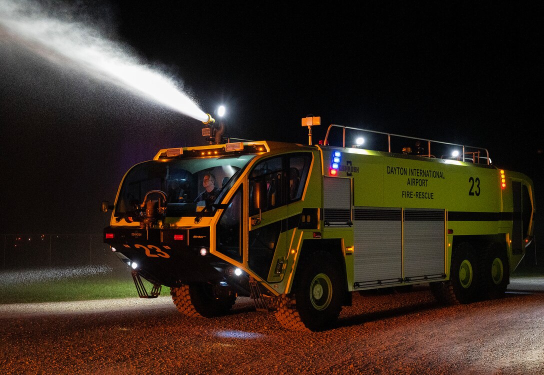 A Dayton International Airport firefighter operates the top turret on his department’s crash truck Oct. 5, 2021, against a live training fire at Wright-Patterson Air Force Base, Ohio. The Federal Aviation Administration requires annual training using both turrets and hose lines. (U.S. Air Force photo by R.J. Oriez)