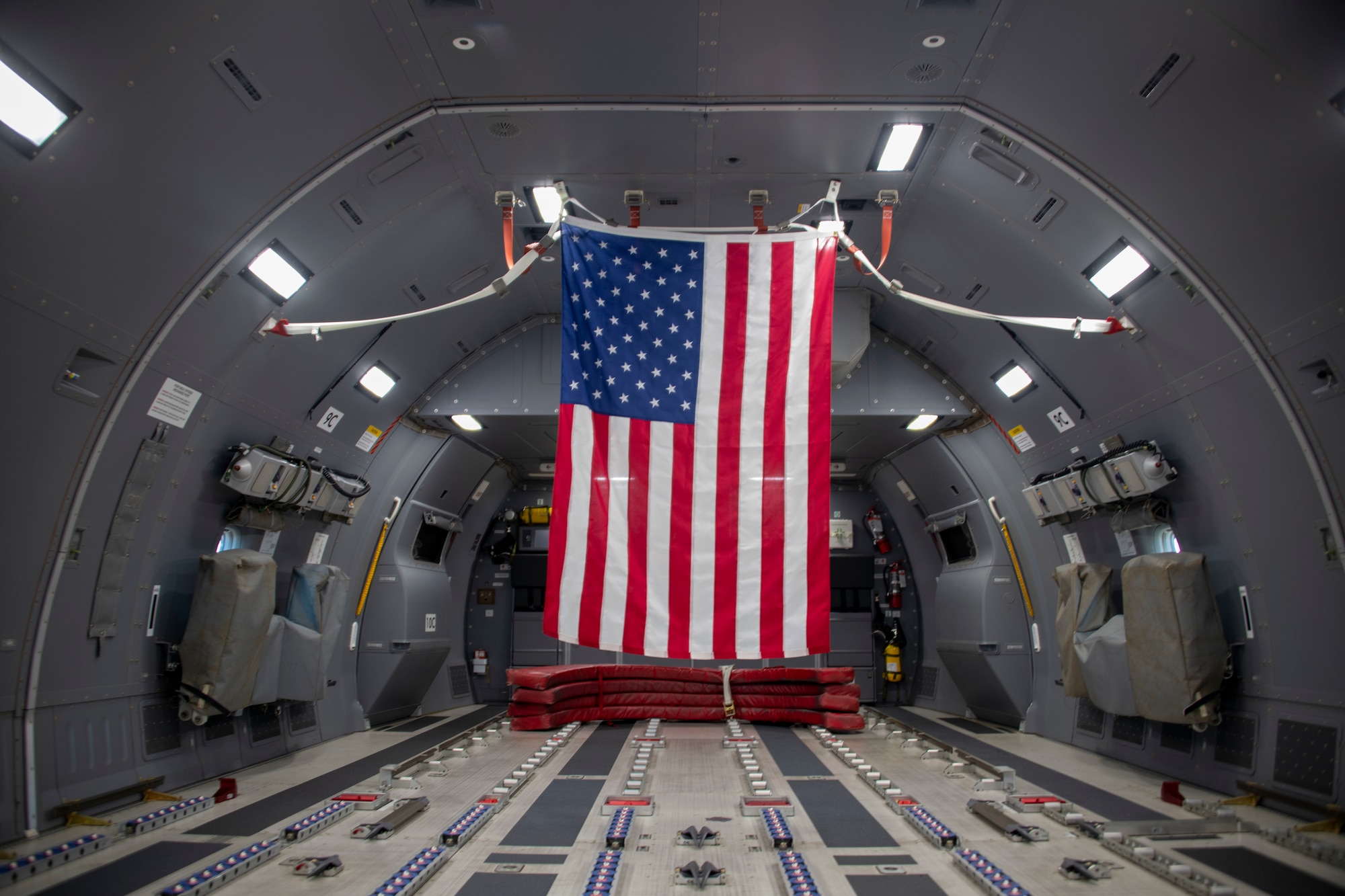 A flag is hung in the back of a KC-46 Pegasus at Altus Air Force Base, Oklahoma, Oct. 8, 2021. This flag was flown inside the aircraft for the funeral of U.S. Army Air Forces 2nd Lt. Ernest Vienneau, former 97th Bombardment Group pilot, to be later given to Veinneau’s family. (U.S. Air Force photo by Staff Sgt. Cody Dowell)