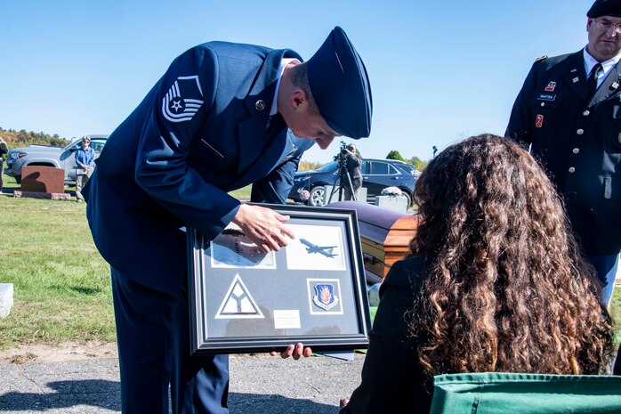 U.S. Air Force Master Sgt. Brad Edwards, 58th Airlift Squadron loadmaster, presents a plaque from the 97th Air Mobility Wing (AMW) to the family of U.S. Army Air Forces 2nd Lt. Ernest Vienneau, former 97th Bombardment Group pilot, during Vienneau’s funeral at Millinocket, Maine, Oct. 9, 2021. The plaque showcased the aircraft that Vienneau flew and the aircraft that was flown over the funeral by members of the 97th AMW. (U.S. Air Force photo by Staff Sgt. Cody Dowell)