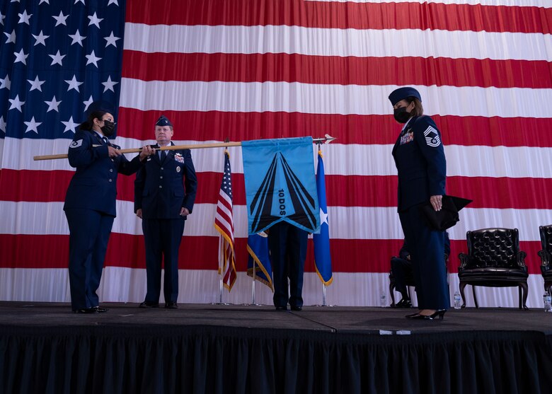 PETERSON SPACE FORCE BASE, Colo. – U.S. Space Force Tech. Sgt. Desiree Valles, Delta 10 Operations Squadron support noncommissioned officer, left, and U.S. Space Force Chief Master Sgt. Karmann-Monique Pogue, Space Delta 10 – Doctrine and Wargaming senior enlisted leader, unfurls the guidon during the unit’s activation ceremony at Peterson Space Force Base, Colorado, Sept. 30, 2021. The 10 DOS Airmen and Guardians are temporarily working at the United States Air Force Academy until the completion of the final organizational structure approval.(U.S. Space Force photo by Staff Sgt. Matthew Coleman-Foster)