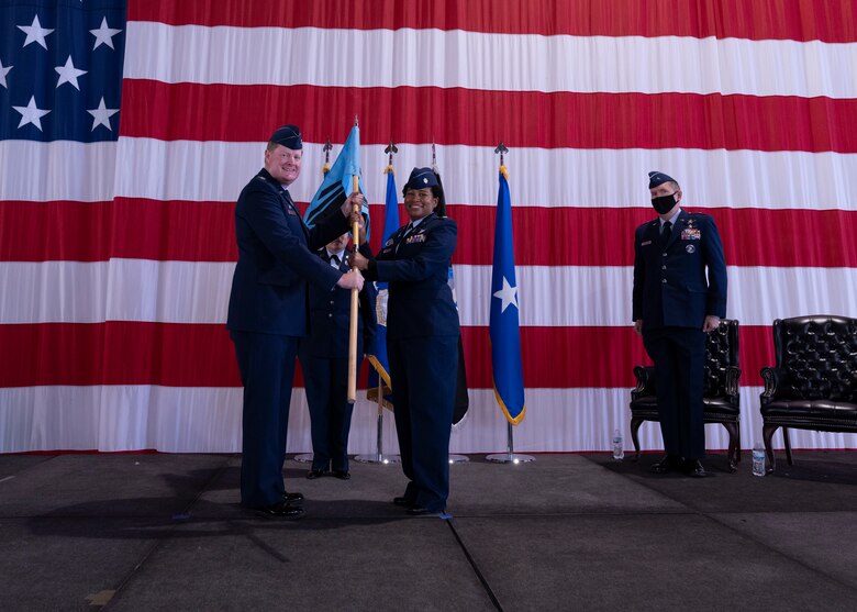 PETERSON SPACE FORCE BASE, Colo. – U.S. Space Force Col. Jack D. Fulmer II, Space Delta 10 – Doctrine and Wargaming commander, passes the Delta 10 Operations Squadron guidon to U.S. Space Force Lt. Col. Jonisa A. McGlown, 10 DOS commander, during the activation ceremony at Peterson Space Force Base, Colorado, Sept. 30, 2021. There are currently four active duty Guardians and Airmen within 10 DOS. (U.S. Space Force photo by Staff Sgt. Matthew Coleman-Foster)