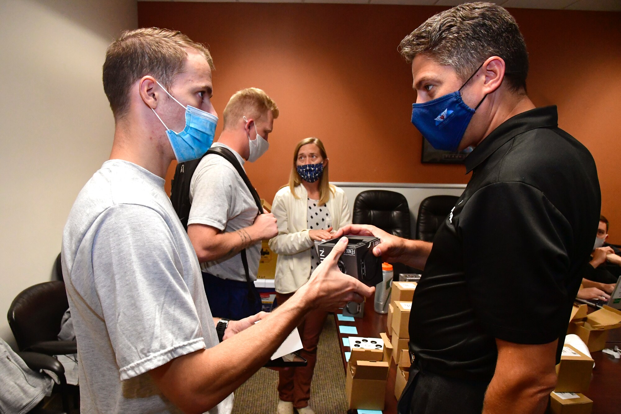 An Airman is handed a GARMIN watch.