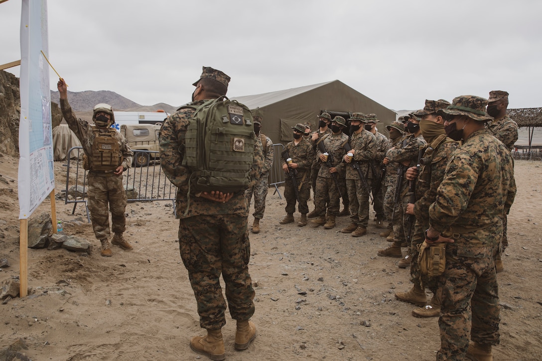 U.S. Marines with Special Purpose Marine Air-Ground Task Force - UNITAS get briefed on the events of an amphibious landing during UNITAS LXII in Salinas, Peru, Oct. 2, 2021. UNITAS is the world's longest-running maritime exercise. Hosted this year by Peru, it brings together multinational forces from twenty countries and includes 29 ships, four submarines, and twenty aircraft conducting operations off the coast of Lima and in the jungles of Iquitos. The exercise trains forces to conduct joint maritime operations and focuses on strengthening partnerships and increasing interoperability and capability between participating naval and marine forces.
