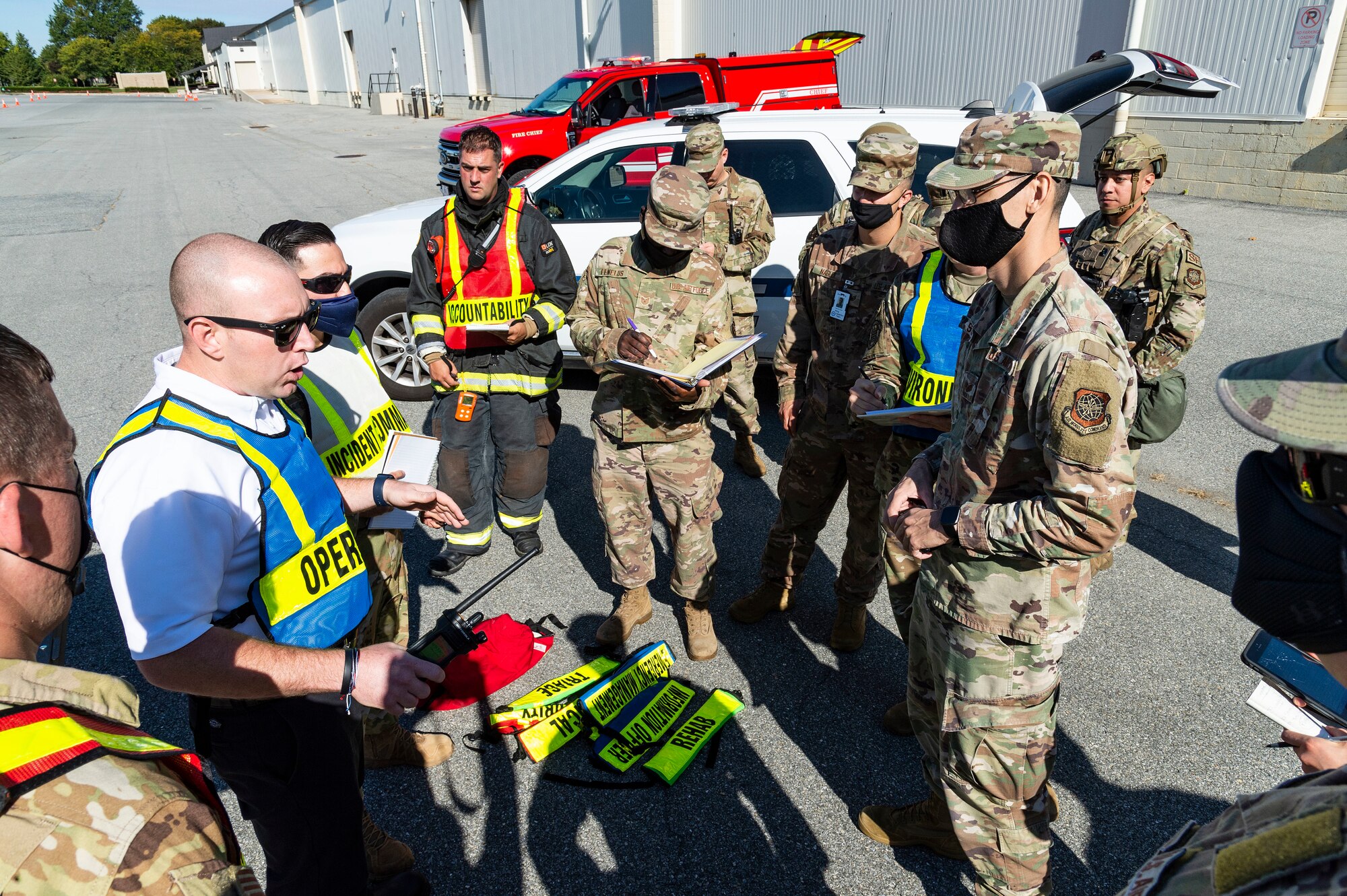Jeremy Lundgren, left, 436th Civil Engineer Squadron fire department section chief, briefs key personnel for a scenario during the Force Protection Major Accident Response Exercise at Dover Air Force Base, Delaware, Oct. 7, 2021. The three-day exercise tested theresponse capabilities of Team Dover through various scenarios in an effort to strengthen their ability to provide rapid-global mobility in challenging conditions. (U.S. Air Force photo by Roland Balik)