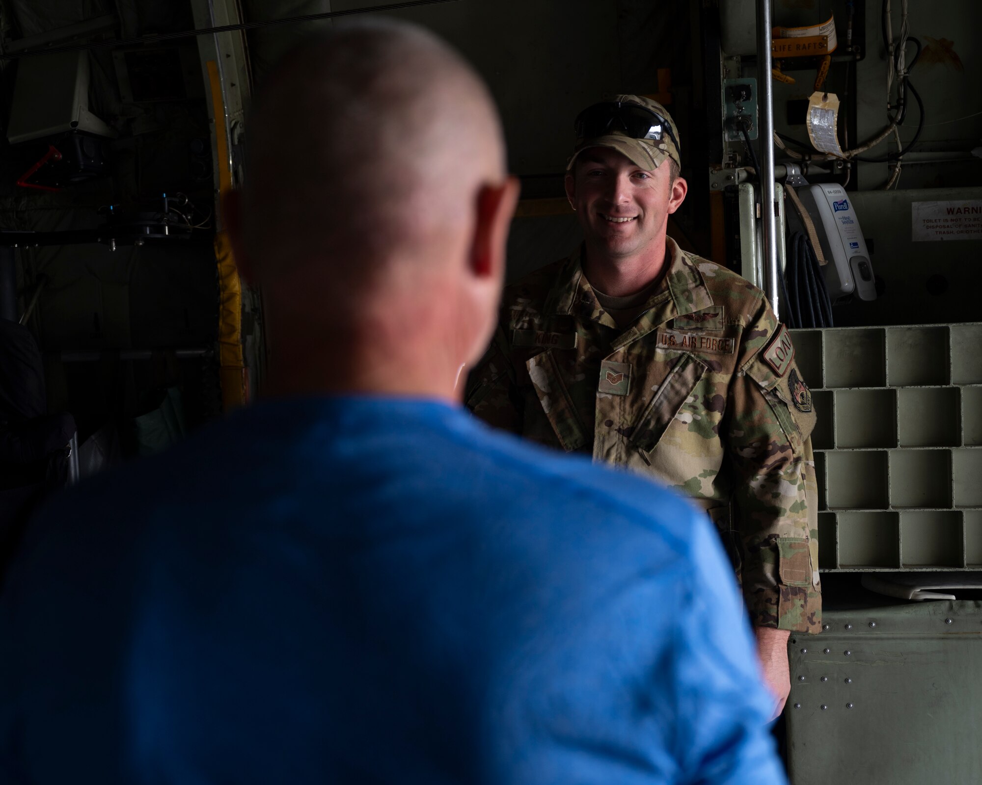 U.S. Air Force Staff Sgt. Brandon King, a loadmaster assigned to the 779th Expeditionary Airlift Squadron, interacts with a visitor during a C-130H Hercules tour at Ali Al Salem Air Base, Kuwait, Oct. 9, 2021.