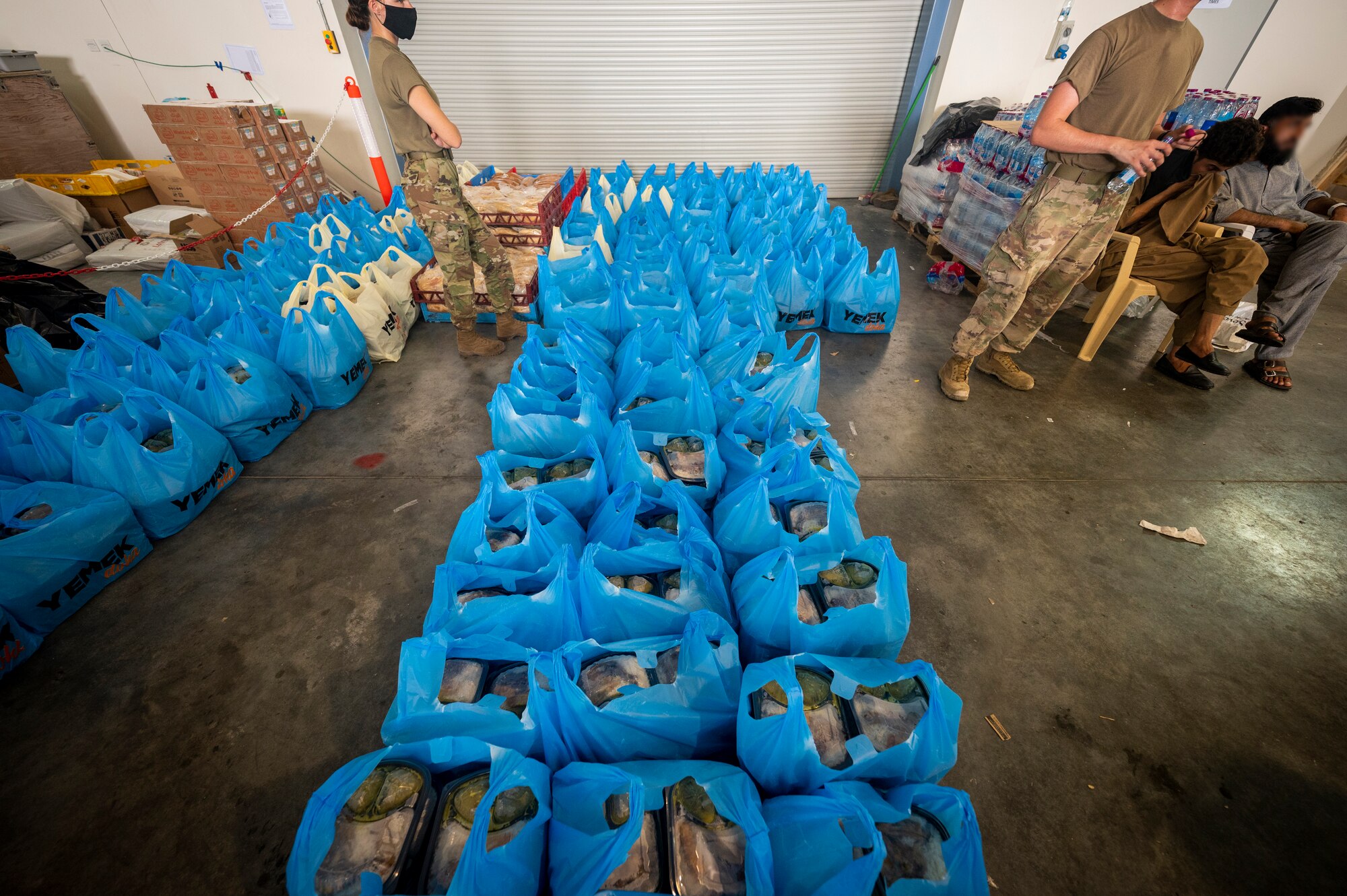 Airmen receive food for Afghanistan evacuees, Aug. 24, 2021, at Al Udeid Air Base, Qatar.