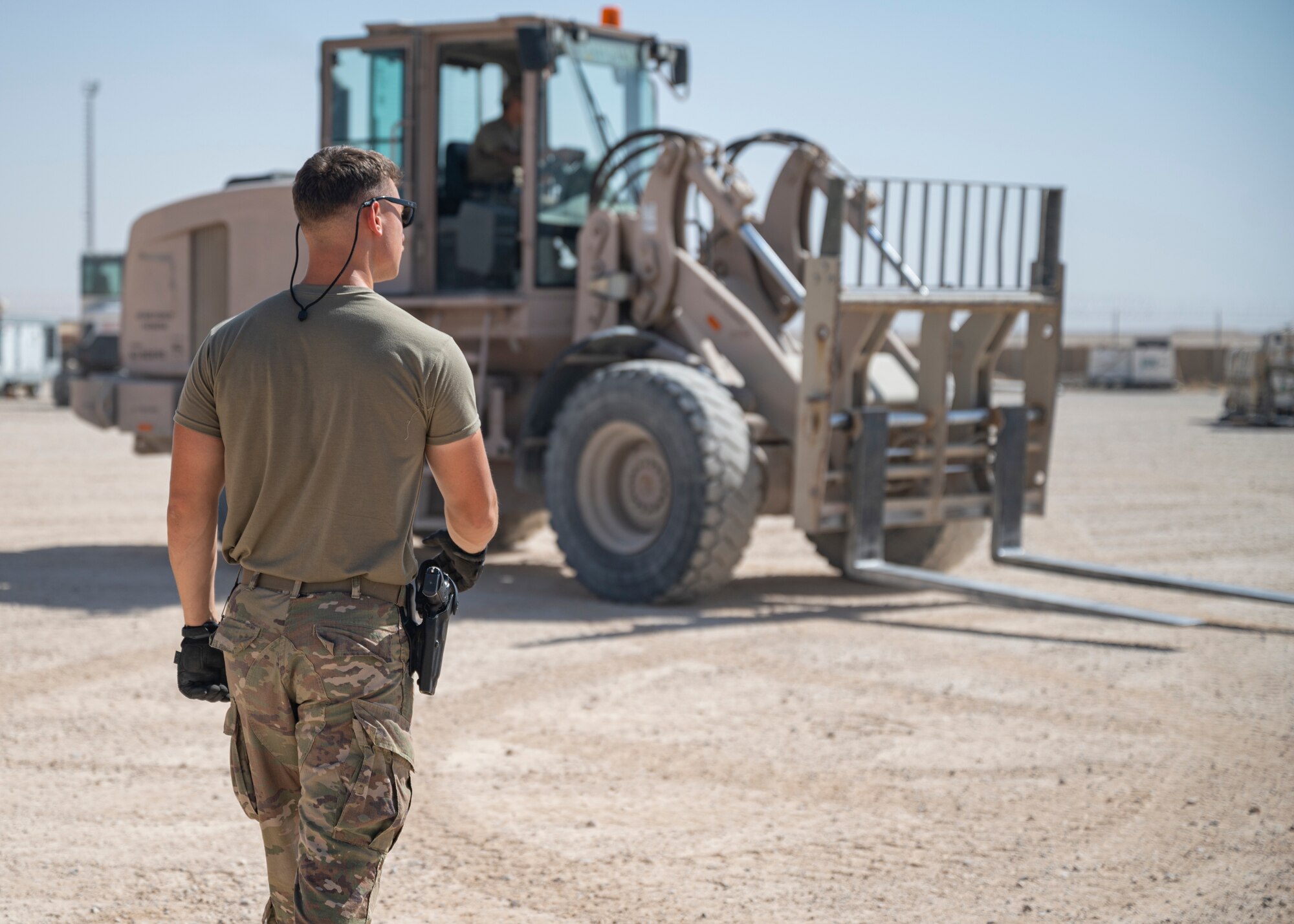 Tech. Sgt. Sean Ofiara observes as U.S. Air Force Staff Sgt. Robert Ignacio, assigned to the 443rd Air Expeditionary Squadron, moves cargo at Al Asad Air Base, Iraq, Sept. 22, 2021.