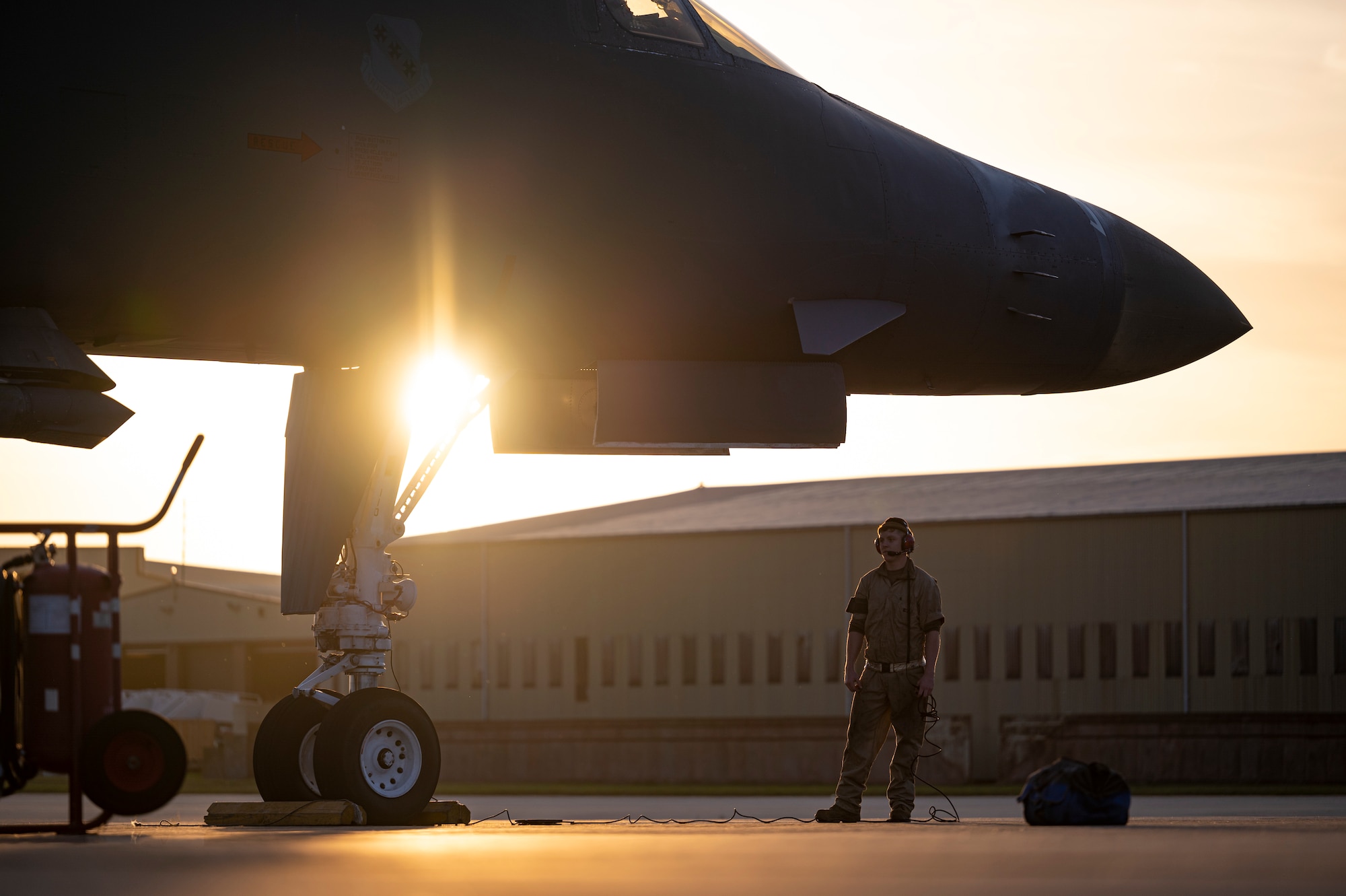 A crew chief assigned to the 9th Expeditionary Bomb Squadron waits while a B-1B Lancer is refueled at RAF Fairford, United Kingdom, Oct. 11, 2021. Petroleum, oil and lubrication Airmen conducted a hot pit refueling at Spangdahlem Air Base, Germany, following its return from a Bomber Task Force Europe mission over the Baltic Sea region to allow aircrew to support a local training mission with Lithuanian forces. (U.S. Air Force photo by Airman 1st Class Josiah Brown)