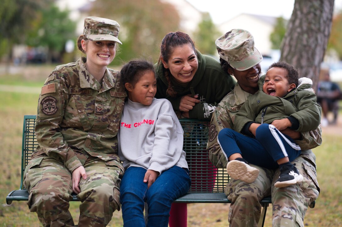 U.S. Air Force Staff Sgt. Karmalita Phipps, 86th Dental Squadron dental technician, middle, prepares for a group photo with her family and two 86th DS dental technicians at Ramstein Air Base, Oct. 5, 2021. October is Down syndrome awareness month. Down syndrome is a genetic disorder that can occur when a child’s 21st chromosome is repeated in their genetic makeup. Phipps’ daughter, Maya Lute, second left, was diagnosed at birth with Down syndrome. (U.S. Air Force photo by Senior Airman Branden Rae)