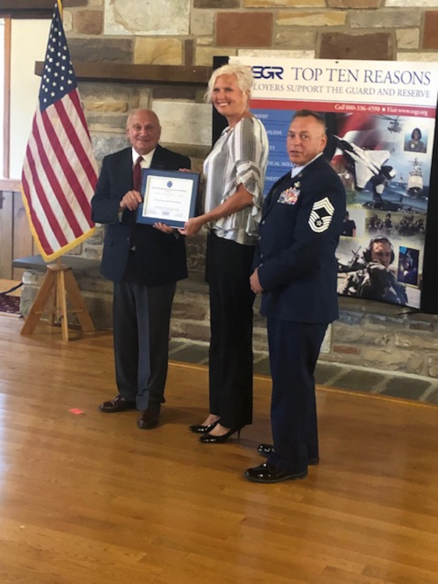 Martin Kuhar (left), Pennsylvania Employer Support of the Guard and Reserve state chair, presents a Patriot Award to Amy Landfair (center), deputy district director of the Pennsylvania State Parole Board at the Keystone Conference Center, Fort Indiantown Gap, Pennsylvania, Aug. 12, 2021.