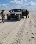 Humvees negotiate the driving course at Smith Point County Park near Mastic Beach, New York, on July 9, 2021, during driver training conducted by the 106th Rescue Wing of the New York Air National Guard. The 106th Rescue Wing fields an immediate response force of five high-axle military vehicles and 20 personnel when natural disasters and emergencies hit Long Island.