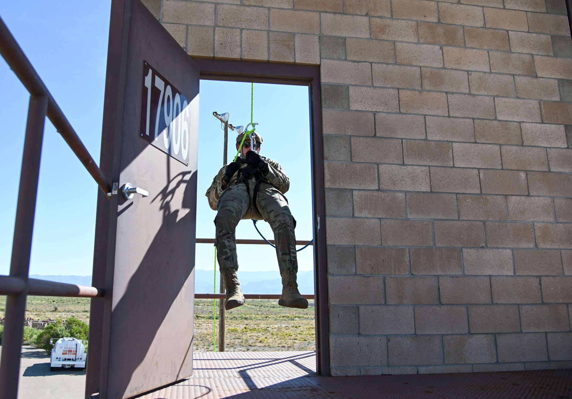 Senior Airman William Rivera Solis, 49th Security Forces Squadron patrolman, practices breaching through a doorway during rappel skills training, Oct. 5, 2021, on Holloman Air Force Base, New Mexico. The rappel skills training was the first of its kind for the 49th Wing. (U.S. Air Force photo by Airman 1st Class Jessica Sanchez-Chen)