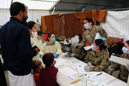 Medical personnel check in Afghan evacuees waiting to receive measles, mumps and rubella and chickenpox vaccines.