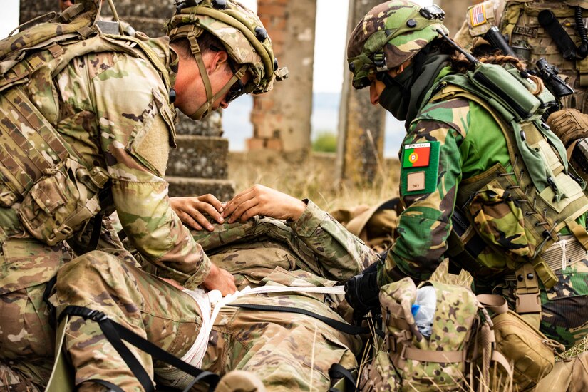 A U.S. Army Soldier assigned to Alpha Company, 1st Battalion, 16th Infantry Regiment “Iron Rangers,” 1st Armored Brigade Combat Team, 1st Infantry Division, and a Portuguese Soldier provide tactical medical care for a simulated casualty in Cincu, Romania
