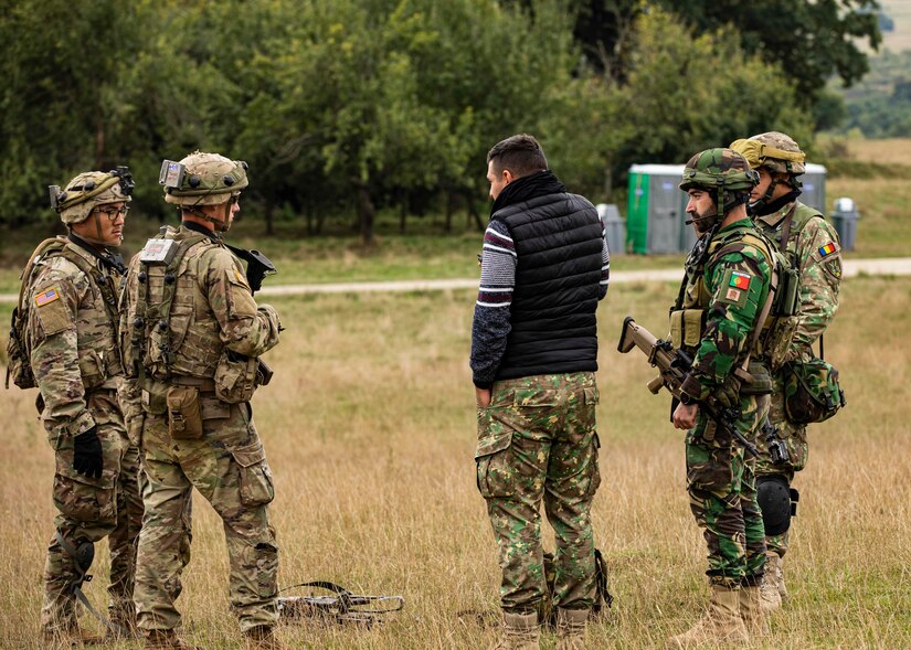 U.S. Army Soldiers assigned to Alpha Company, 1st Battalion, 16th Infantry Regiment “Iron Rangers,” 1st Armored Brigade Combat Team, 1st Infantry Division, a portuguese Soldier and a Romanian Soldier meet with the “mayor” of a town during a simulated key leader engagement training exercise in Cincu, Romania