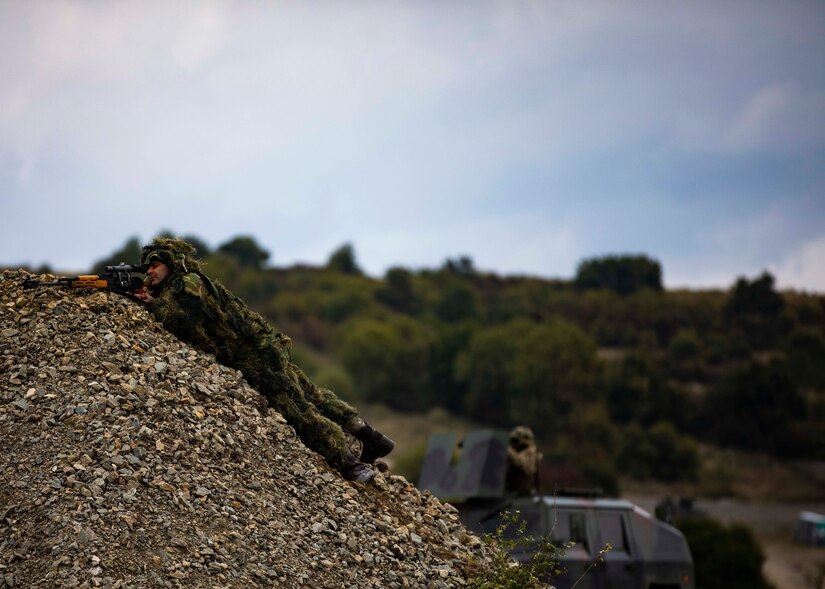 A Romanian sniper aims down his sights during a multinational situational training exercise in Cincu, Romania