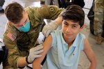 Pvt. Hayden McClure, an Army medic assigned to 1st Squadron, 2nd Cavalry Regiment, administers an MMR vaccine to an Afghan evacuee at Rhine Ordnance Barracks, Germany