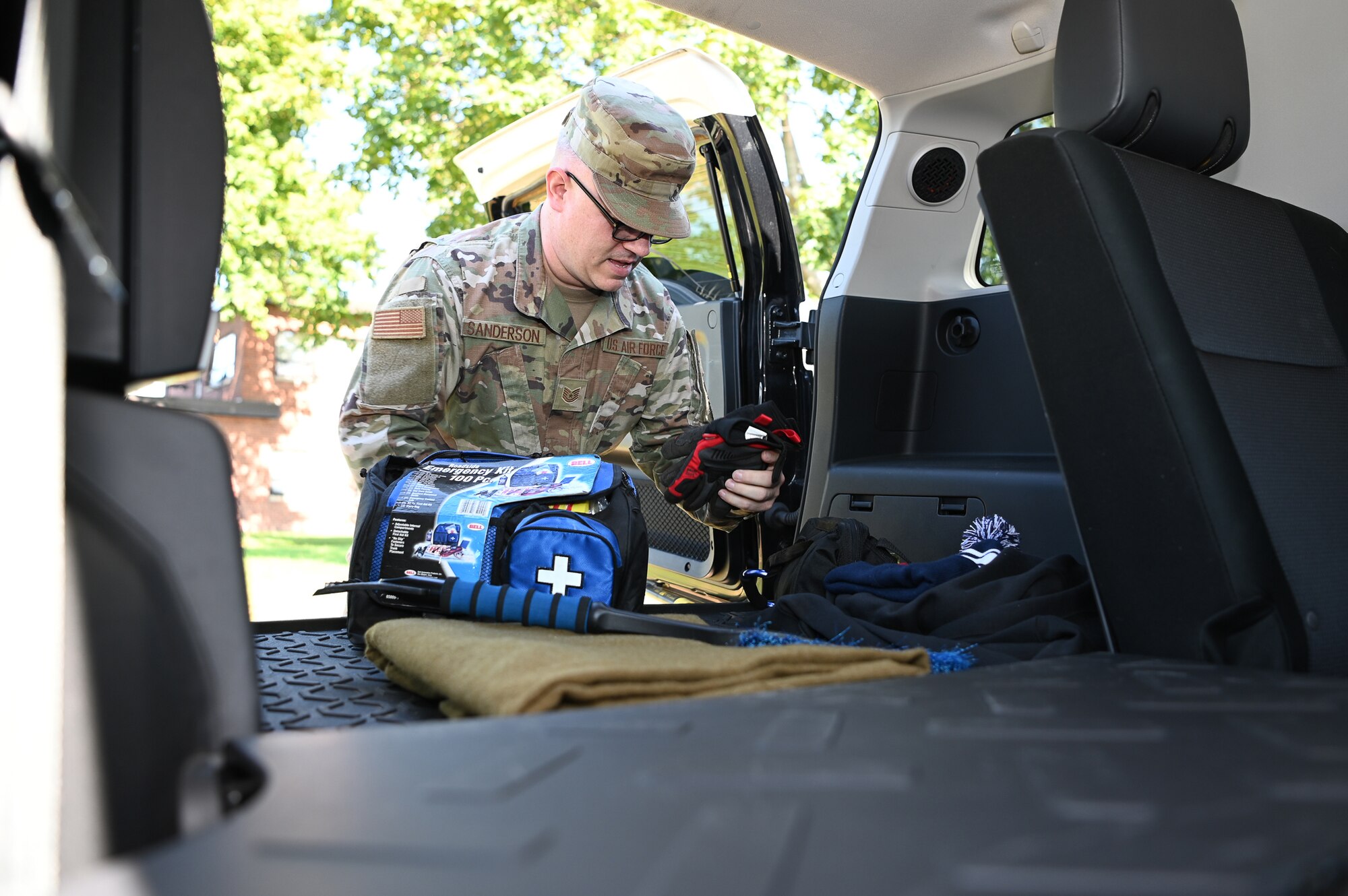 Airman loads emergency kit into vehicle