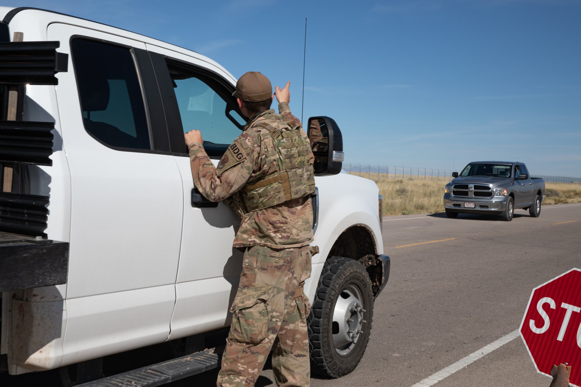 An Airman deployed with the 822nd Base Defense Squadron from Moody Air Force Base, Georgia, directs traffic down the road from Aman Omid Village on Holloman Air Force Base, New Mexico, Oct. 7, 2021. The Department of Defense, through the U.S. Northern Command, and in support of the Department of State and Department of Homeland Security, is providing transportation, temporary housing, medical screening, and general support for at least 50,000 Afghan evacuees at suitable facilities, in permanent or temporary structures, as quickly as possible. This initiative provides Afghan evacuees essential support at secure locations outside Afghanistan. (U.S. Army photo by Spc. Nicholas Goodman)