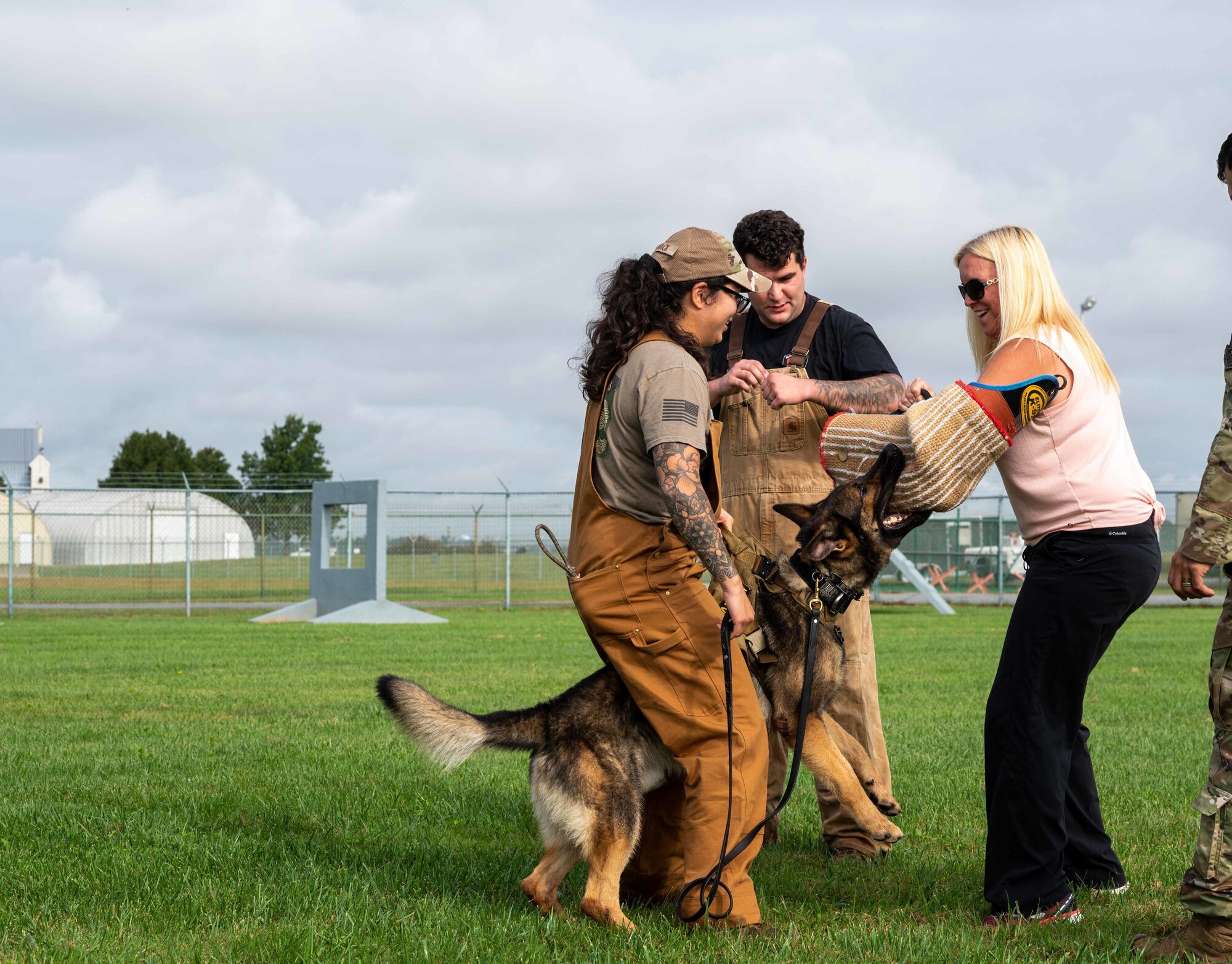 Sandy Unkrur, Dover Air Force Base key spouse, participates in a military working dog demo during a key spouse immersion tour at Dover AFB, Delaware, Oct. 13, 2021. The tour featured facilities around base such as the Bedrock Innovation Lab, military working dog kennels and Air Force Mortuary Affairs Operations. The immersion aimed to familiarize and better equip spouses in assisting Airmen and their families. (U.S. Air Force photo by Senior Airman Faith Schaefer)