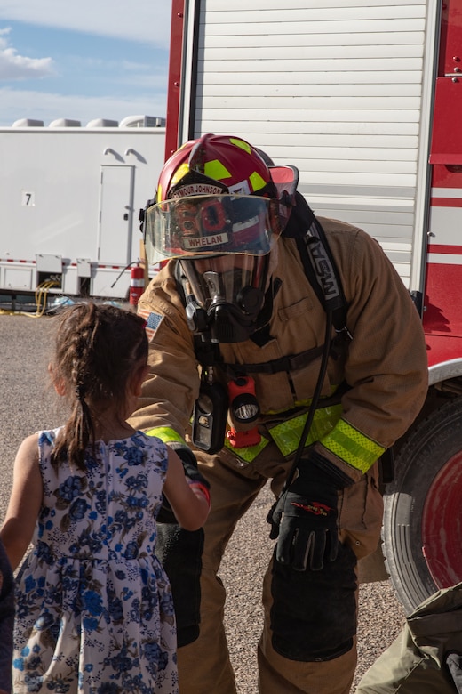 Tech. Sgt. Matt Whelan, Task Force-Holloman firefighter deployed from Seymour Johnson Air Force Base, North Carolina, gives a fist bump to an Afghan child on Holloman Air Force Base, New Mexico, Oct. 11, 2021. The Department of Defense, through the U.S. Northern Command, and in support of the Department of State and Department of Homeland Security, is providing transportation, temporary housing, medical screening, and general support for at least 50,000 Afghan evacuees at suitable facilities, in permanent or temporary structures, as quickly as possible. This initiative provides Afghan evacuees essential support at secure locations outside Afghanistan. 

(U.S. Army photo by Spc. Nicholas Goodman)