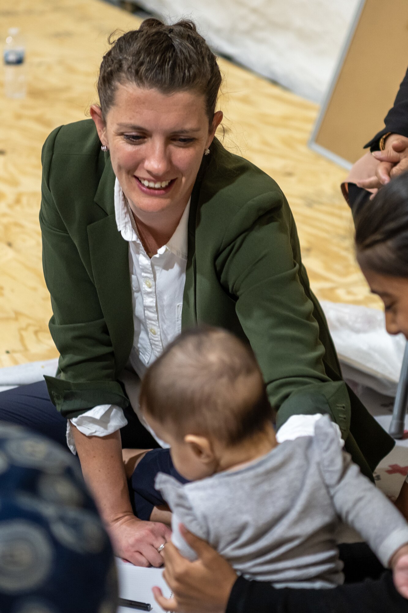 Erin Cooper, a woman, peace and policy analyst with the Secretary of Defense and deployed to Task Force-Holloman as a gender advisor, plays with a child during a women’s meeting at Aman Omid Village on Holloman Air Force Base, New Mexico, Oct. 7, 2021. The Department of Defense, through U.S. Northern Command, and in support of the Department of Homeland Security is providing transportation, temporary housing, medical screening, and general support for at least 50,000 Afghans at suitable facilities, in permanent or temporary structures, as quickly as possible. This initiative provides Afghan personnel essential support at secure locations outside Afghanistan. (U.S. Air Force photo by Senior Airman Skyler Combs)