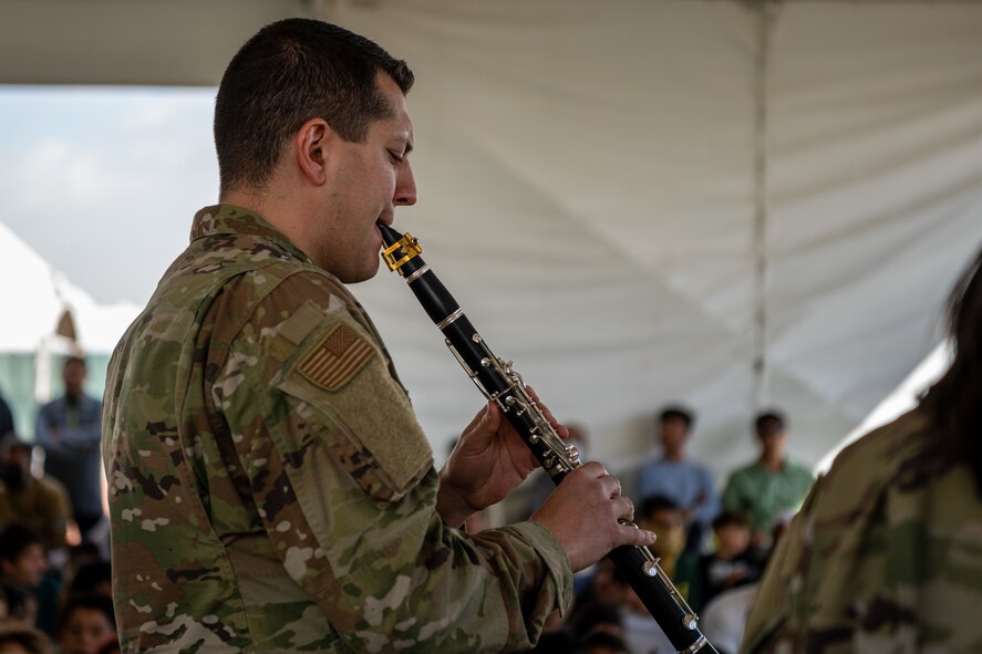 Members of the U.S. Air Force Academy Winds musical ensemble perform for Afghan evacuees at Aman Omid Village on Holloman Air Force Base, New Mexico, Oct. 12, 2021. The Department of Defense, through U.S. Northern Command, and in support of the Department of Homeland Security is providing transportation, temporary housing, medical screening, and general support for at least 50,000 Afghans at suitable facilities, in permanent or temporary structures, as quickly as possible. This initiative provides Afghan personnel essential support at secure locations outside Afghanistan. (U.S. Air Force photo by Senior Airman Skyler Combs)