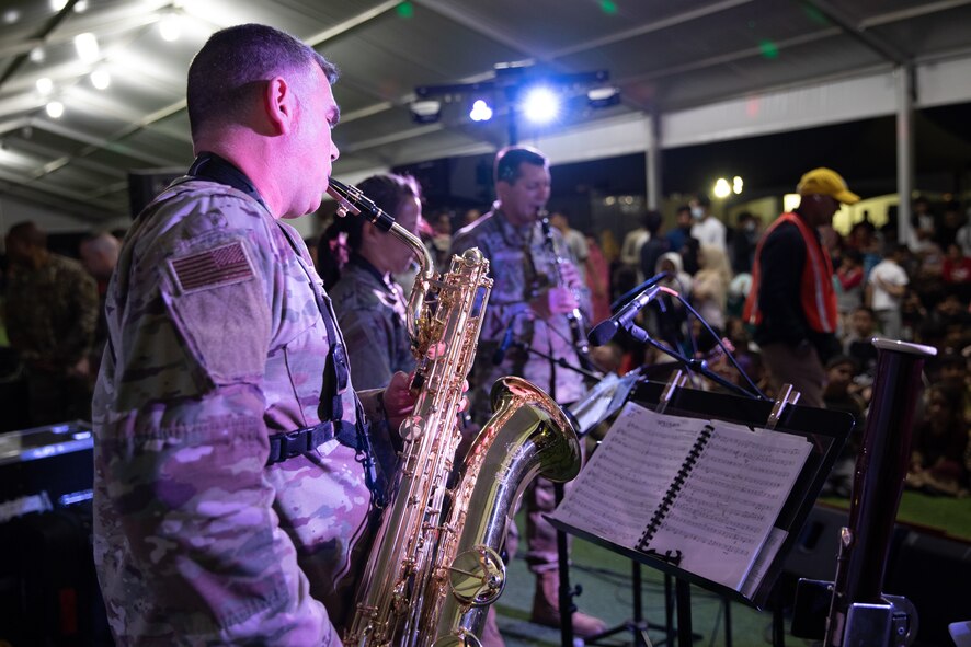 Academy Winds from the U.S. Air Force Academy, performs at Aman Omid Village for Afghan evacuees on Holloman Air Force Base, New Mexico, Oct. 13, 2021. The Department of Defense, through the U.S. Northern Command, and in support of the Department of State and Department of Homeland Security, is providing transportation, temporary housing, medical screening, and general support for at least 50,000 Afghan evacuees at suitable facilities, in permanent or temporary structures, as quickly as possible. This initiative provides Afghan evacuees essential support at secure locations outside Afghanistan. (U.S. Army photo by Spc. Nicholas Goodman)