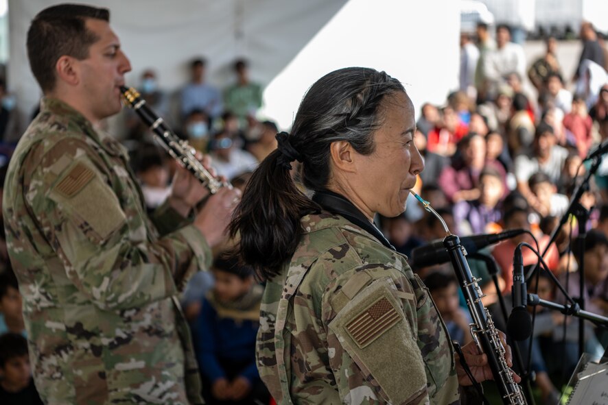 Members of the U.S. Air Force Academy Winds musical ensemble perform for Afghan evacuees at Aman Omid Village on Holloman Air Force Base, New Mexico, Oct. 12, 2021. The Department of Defense, through U.S. Northern Command, and in support of the Department of Homeland Security is providing transportation, temporary housing, medical screening, and general support for at least 50,000 Afghans at suitable facilities, in permanent or temporary structures, as quickly as possible. This initiative provides Afghan personnel essential support at secure locations outside Afghanistan. (U.S. Air Force photo by Senior Airman Skyler Combs)