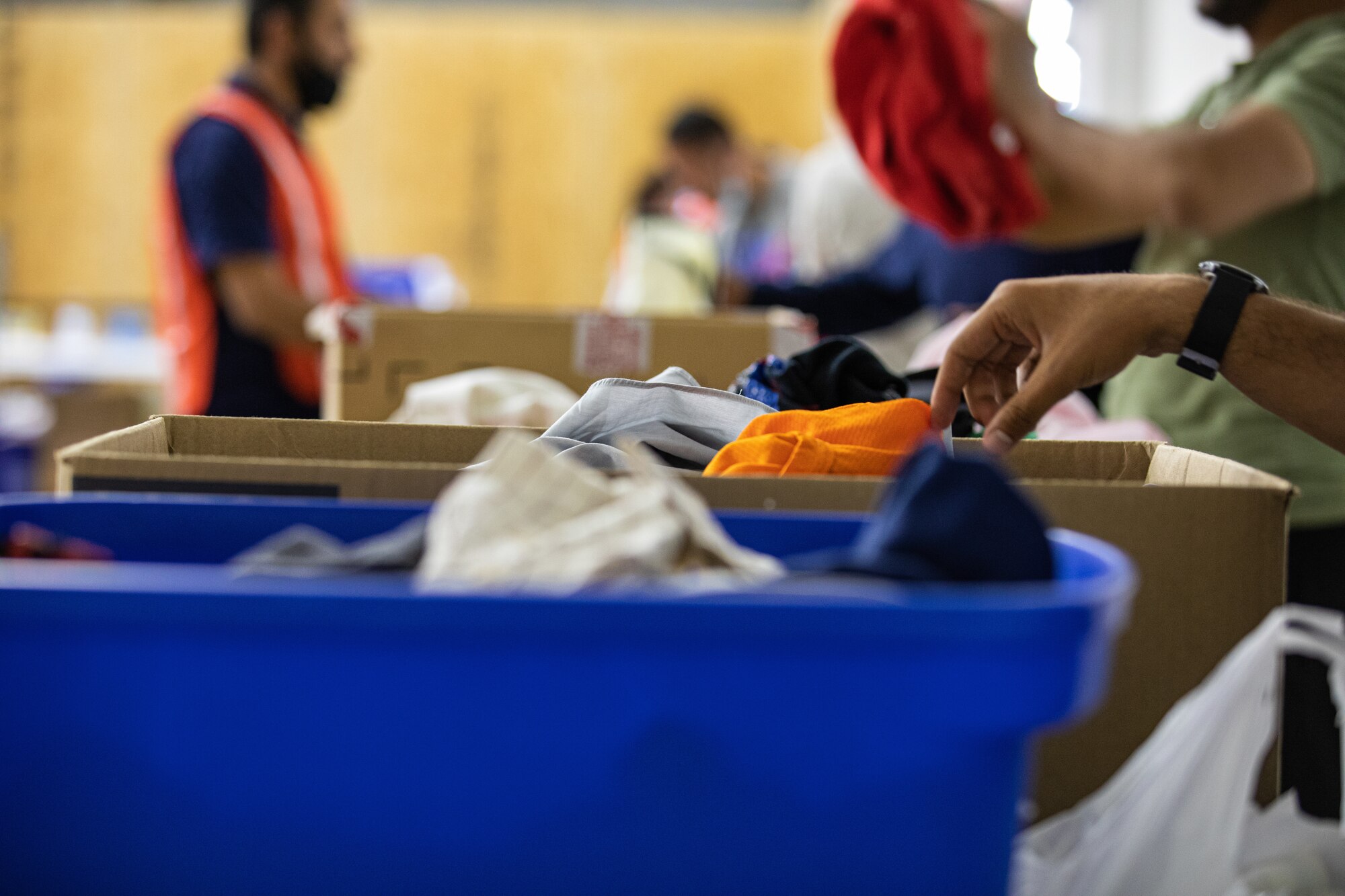 Afghan evacuees look through donated clothes at the donation center at Task Force-Holloman on Holloman Air Force Base, New Mexico Oct. 9, 2021. The Department of Defense, through U.S. Northern Command, and in support of the Department of Homeland Security, is providing transportation, temporary housing, medical screening, and general support for at least 50,000 Afghan evacuees at suitable facilities, in permanent or temporary structures, as quickly as possible. This initiative provides Afghan personnel essential support at secure locations outside Afghanistan. (U.S. Army photo by Spc. Nicholas Goodman)