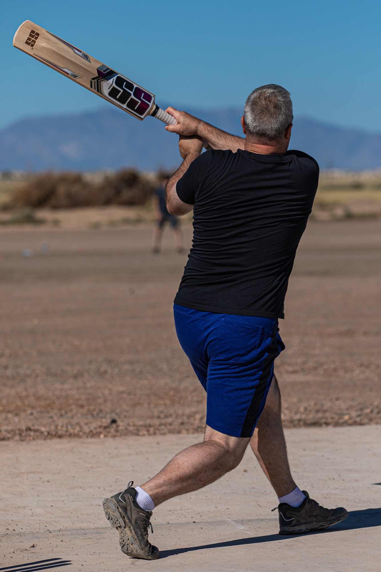 Col. Kent Harbough, Task Force-Holloman chief of staff deployed from Battle Creek Air National Guard Base, Michigan, swings a bat during a cricket game between U.S. service members and Afghan evacuees at Aman Omid Village on Holloman Air Force Base, New Mexico, Oct. 9, 2021. The Department of Defense, through U.S. Northern Command, and in support of the Department of Homeland Security, is providing transportation, temporary housing, medical screening, and general support for at least 50,000 Afghan evacuees at suitable facilities, in permanent or temporary structures, as quickly as possible. This initiative provides Afghan personnel essential support at secure locations outside Afghanistan. (U.S. Army photo by Pfc. Anthony Sanchez)