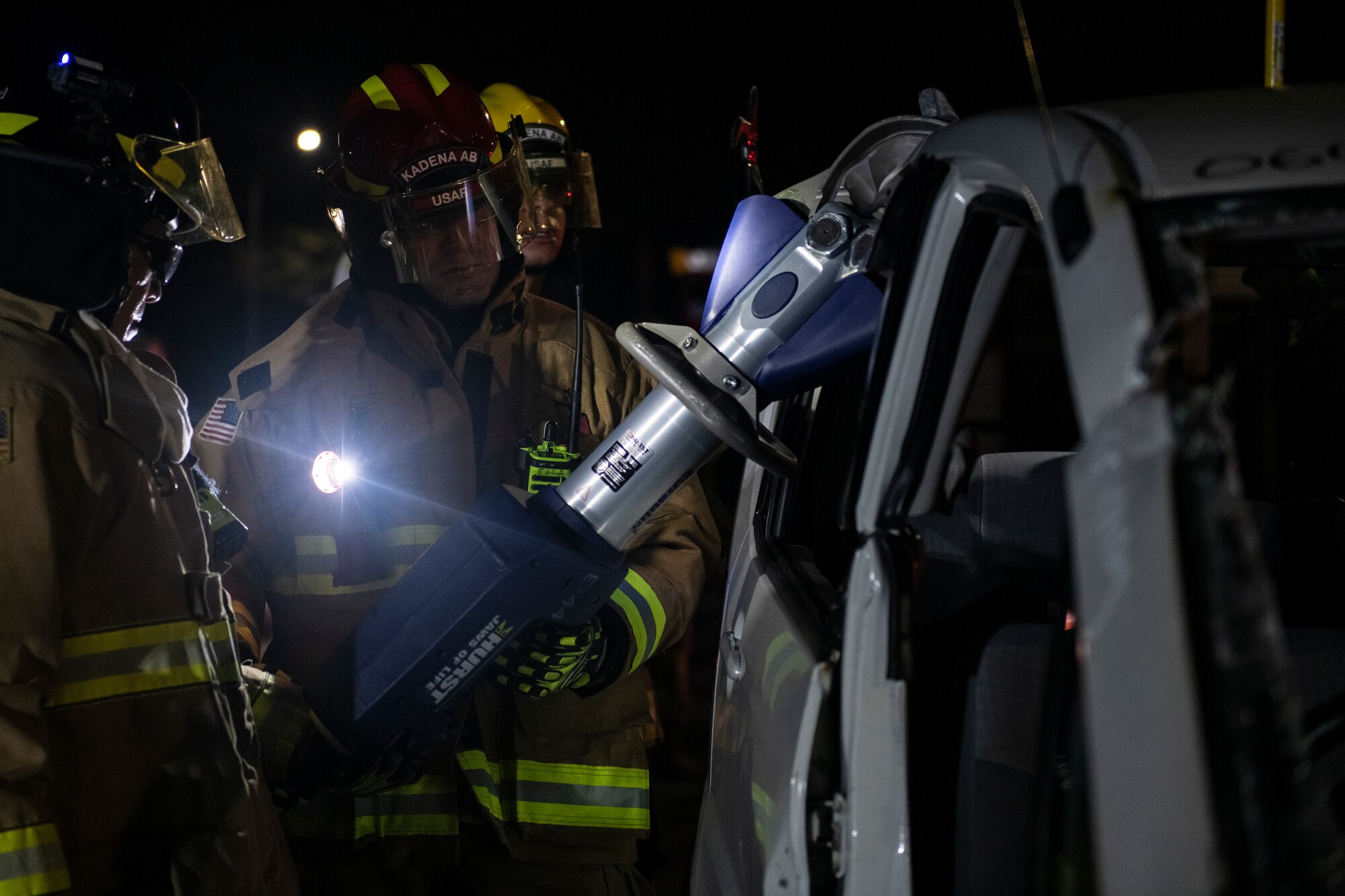 U.S. Air Force Staff Sgt. Garrett Morrison, 18th Civil Engineering Squadron firefighter, uses hydraulic cutters to dismantle a vehicle during a Fire Prevention Week demonstration at Kadena Air Base, Japan, Oct. 7, 2021. Various hydraulic tools such as cutters, spreaders, and rams are used by emergency rescue personnel to assist in the extrication of victims from vehicle accidents. (U.S. Air Force photo by Senior Airman Jessi Monte)