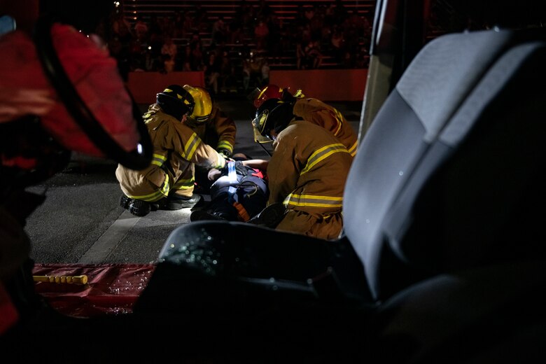 U.S. Air Force firefighters assigned to the 18th Civil Engineering Squadron secure the victim of a simulated car accident during a Fire Prevention Week demonstration at Kadena Air Base, Japan, Oct. 7, 2021. The event demonstrated the 18th CES’s ability to quickly respond to distress calls and the various capabilities they use to handle emergency situations. (U.S. Air Force photo by Senior Airman Jessi Monte)