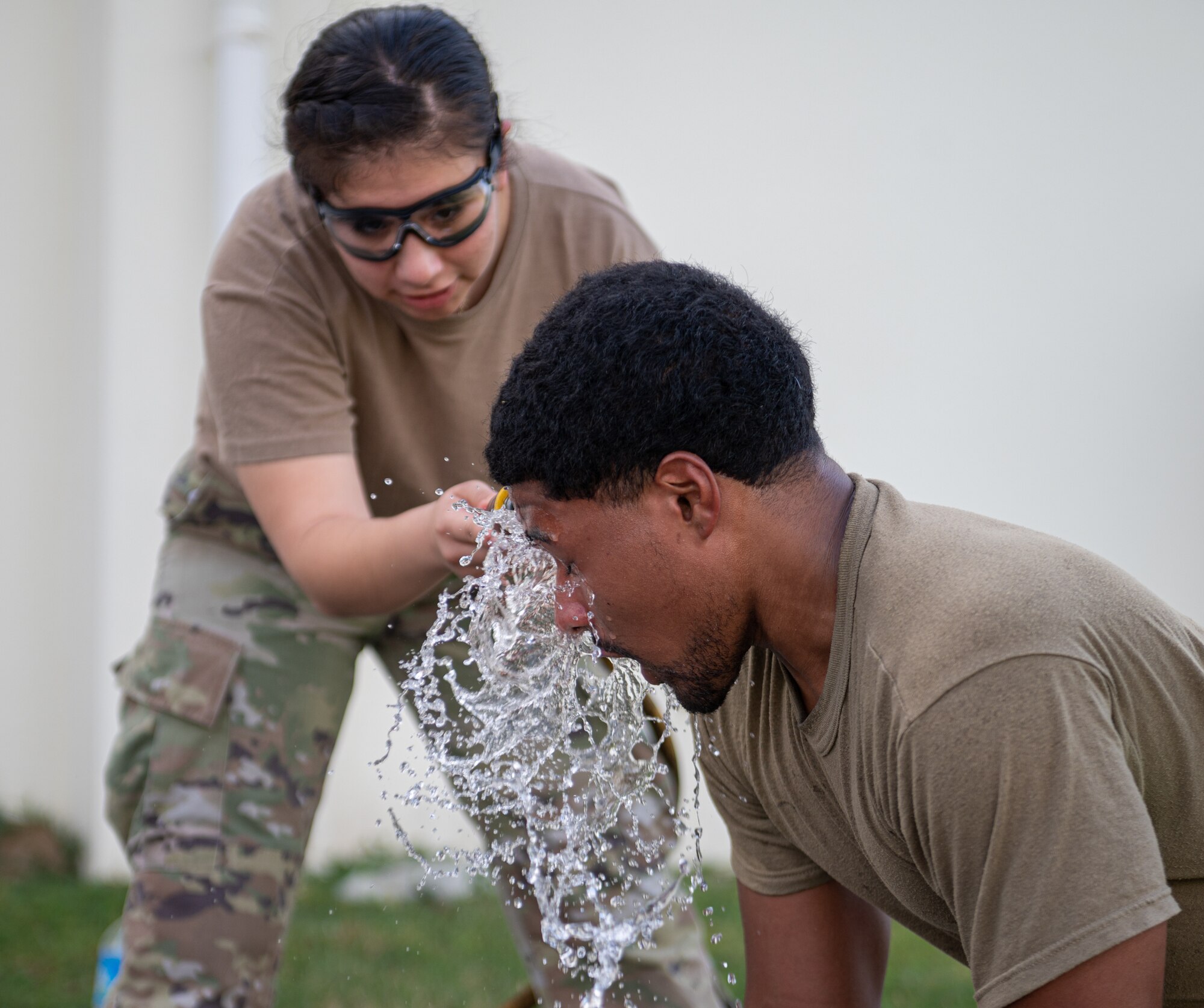 Airmen getting sprayed with water in his eyes.