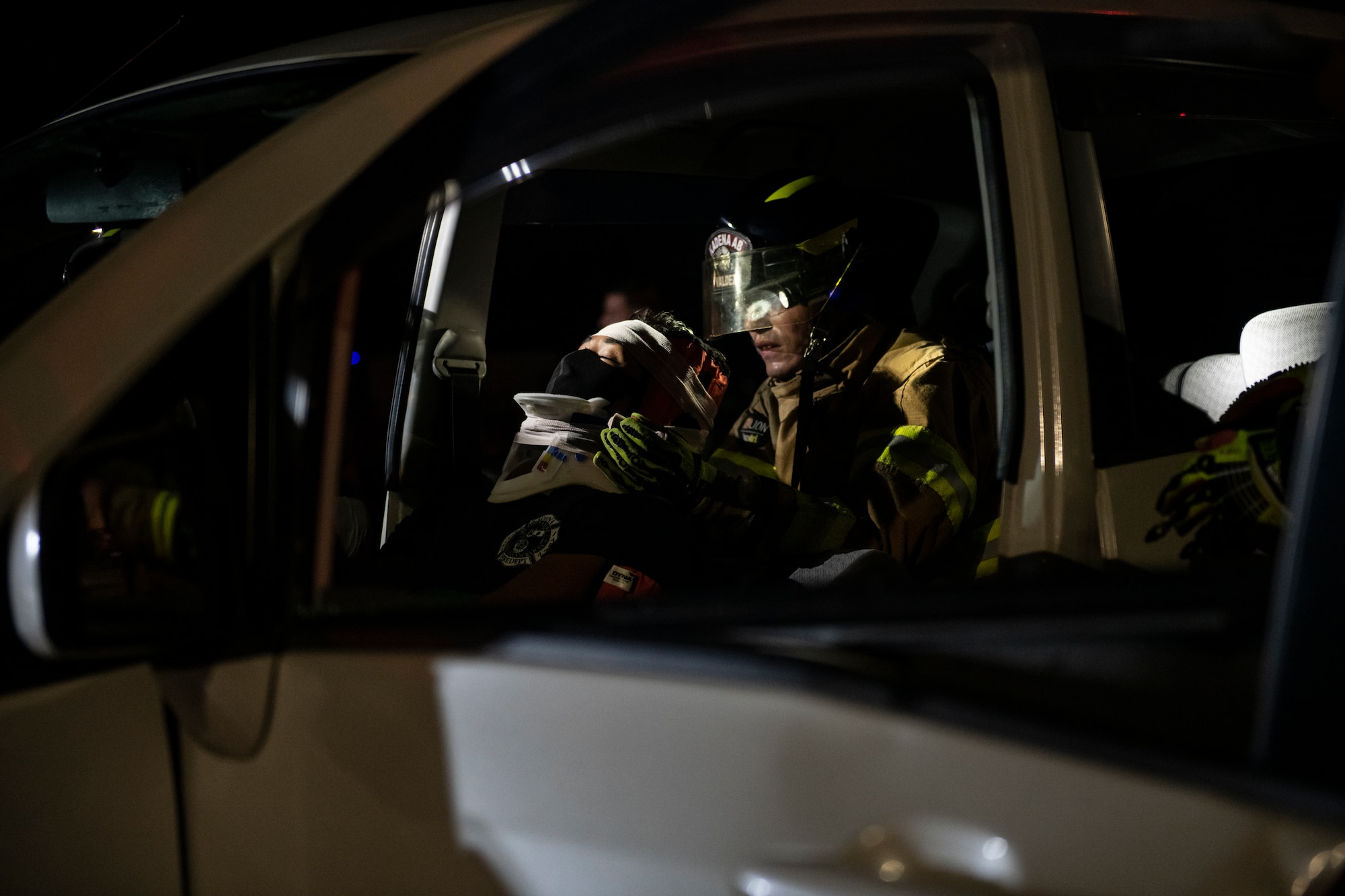 Senior Airman Colton Valdez, 18th Civil Engineering Squadron firefighter, right, supports the head of a simulated victim, Aoi Kuniyoshi, 18th CES firefighter, during a Fire Prevention Week demonstration at Kadena Air Base, Japan, Oct. 7, 2021. Firefighters are trained to properly secure victims to prevent further strain or injury during extrication from an automobile accident. (U.S. Air Force photo by Senior Airman Jessi Monte)