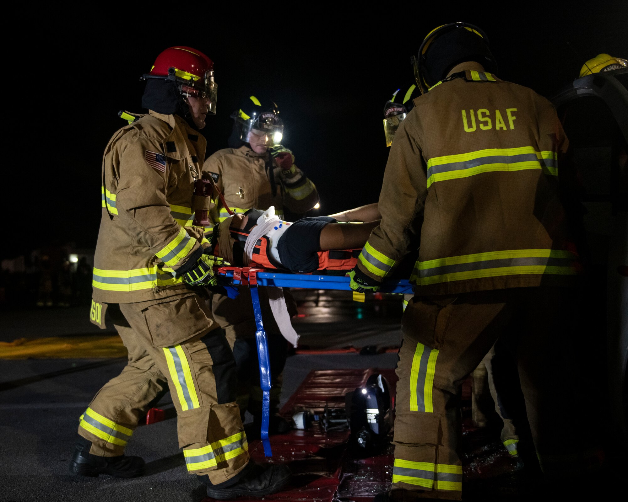 U.S. Air Force firefighters assigned to the 18th Civil Engineering Squadron remove a victim from a simulated car accident during a Fire Prevention Week demonstration at Kadena Air Base, Japan, Oct. 7, 2021. Firefighters are trained to properly secure victims to prevent further strain or injury during extrication from an automobile accident. (U.S. Air Force photo by Senior Airman Jessi Monte)