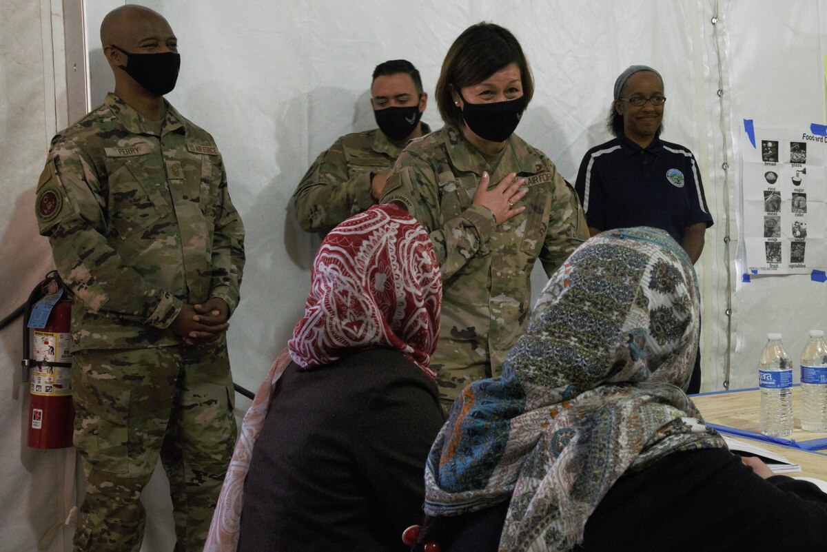 Chief Master Sgt. of the Air Force JoAnne S. Bass greets Afghan students during their English lessons at Aman Omid Village as part of a visit to Task Force-Holloman on Holloman Air Force Base, New Mexico, Oct. 13, 2021. The Department of Defense, through U.S. Northern Command, and in support of the Department of State and Department of Homeland Security, is providing transportation, temporary housing, medical screening, and general support for at least 50,000 Afghan evacuees at suitable facilities, in permanent or temporary structures, as quickly as possible. This initiative provides Afghan evacuees essential support at secure locations outside Afghanistan. (U.S. Navy photo by Mass Communications Specialist 1st Class Sarah Rolin)