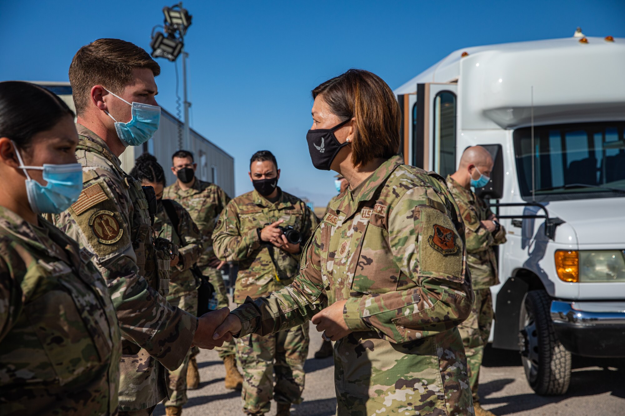 Chief Master Sgt. of the Air Force JoAnne S. Bass presents a coin to Staff Sgt. Wesley Ferguson, Task Force-Holloman security forces squad leader deployed from Moody Air Force Base, Georgia, on Holloman AFB, New Mexico, Oct. 13, 2021. The Department of Defense, through U.S. Northern Command, and in support of the Department of Homeland Security, is providing transportation, temporary housing, medical screening, and general support for at least 50,000 Afghan evacuees at suitable facilities, in permanent or temporary structures, as quickly as possible. This initiative provides Afghan personnel essential support at secure locations outside Afghanistan. (U.S. Army photo by Pfc. Anthony Sanchez)