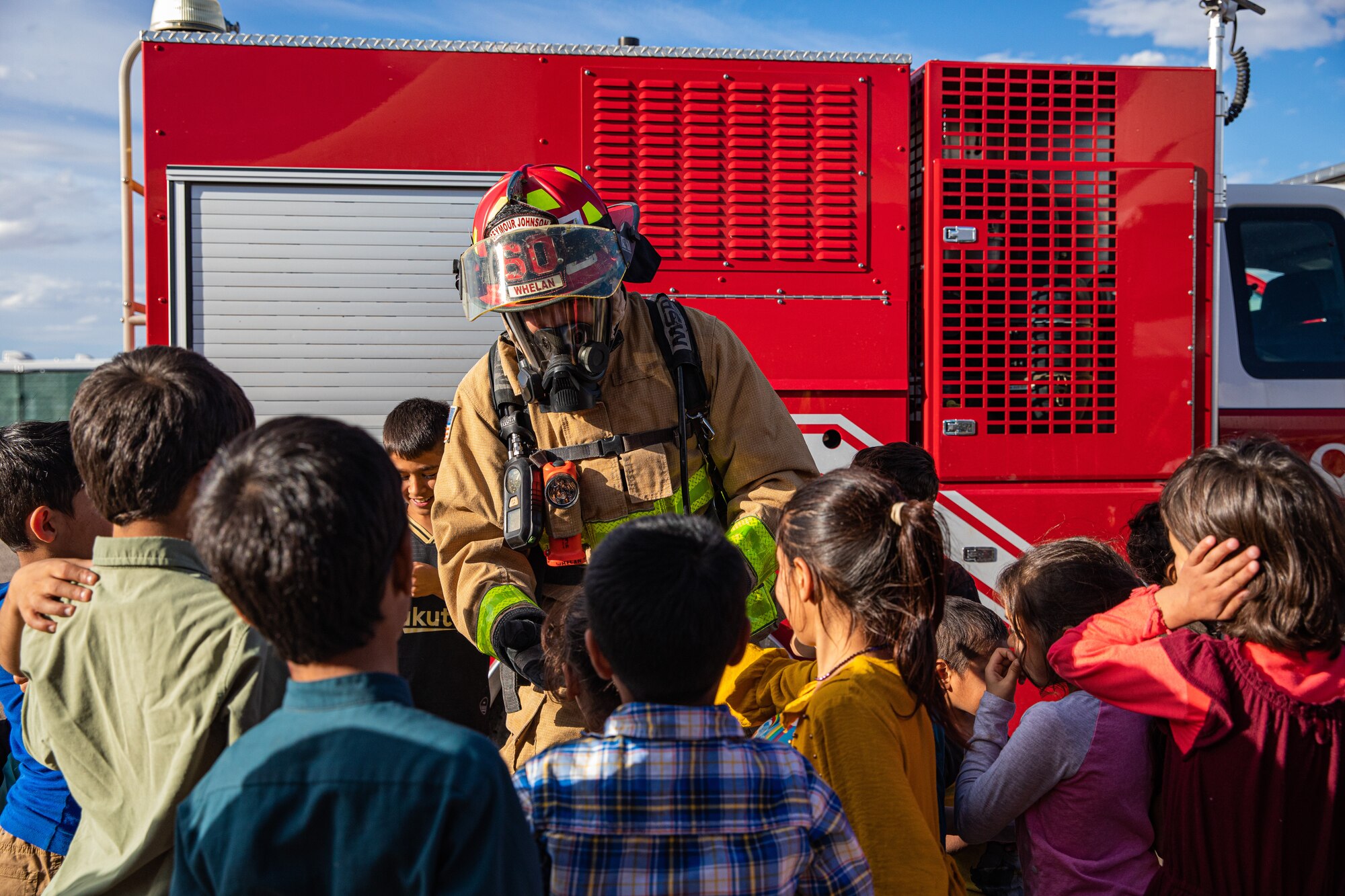 Tech. Sgt. Matt Whelan, Task Force-Holloman firefighter deployed from Seymour Johnson Air Force Base, North Carolina, speaks to Afghan children during a safety class at Aman Omid Village on Holloman Air Force Base, New Mexico, Oct. 11, 2021. The Department of Defense, through U.S. Northern Command, and in support of the Department of Homeland Security, is providing transportation, temporary housing, medical screening, and general support for at least 50,000 Afghan evacuees at suitable facilities, in permanent or temporary structures, as quickly as possible. This initiative provides Afghan personnel essential support at secure locations outside Afghanistan. (U.S. Army photo by Pfc. Anthony Sanchez)