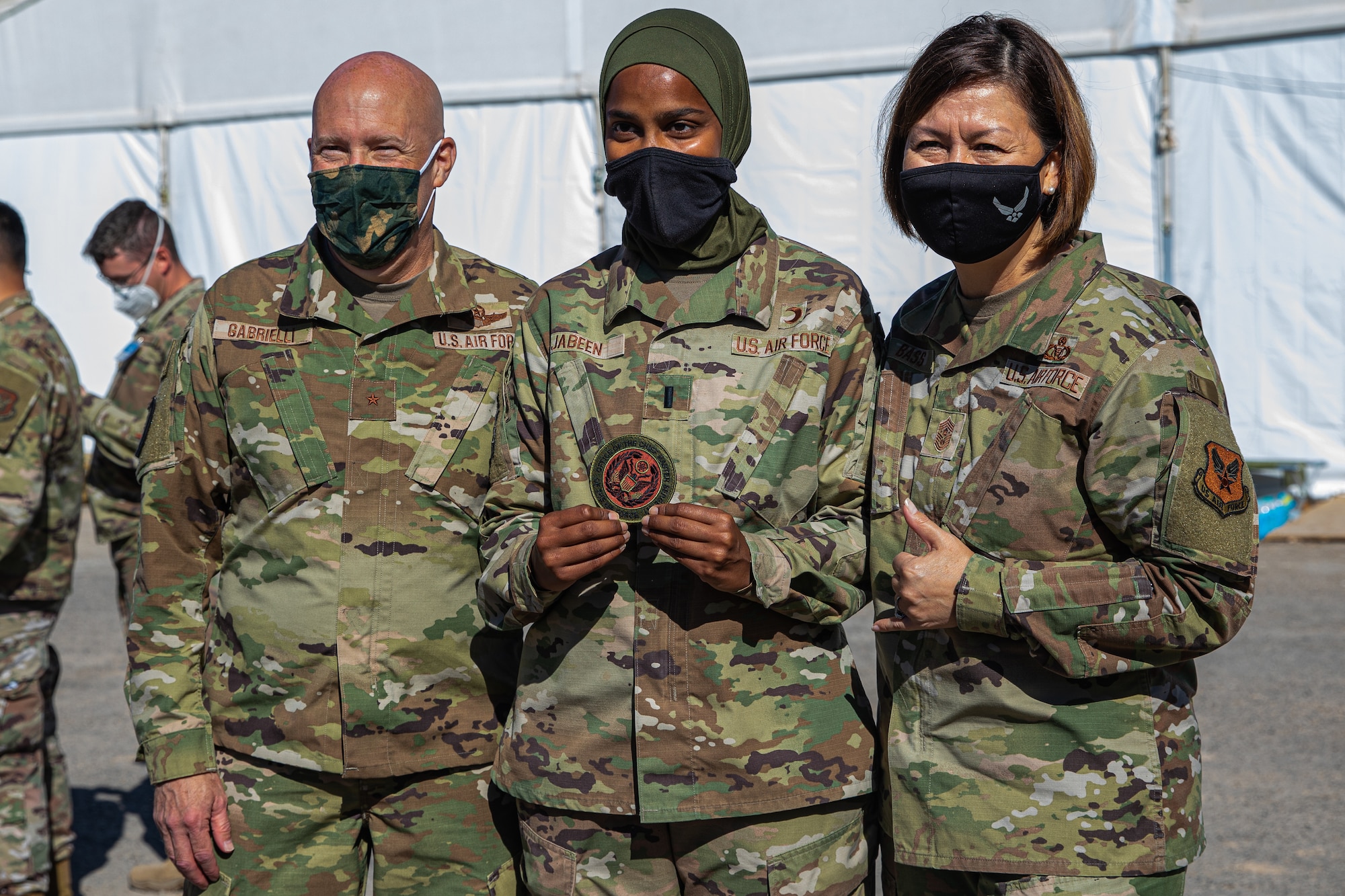 (From left to right) Brig. Gen. Daniel Gabrielli, Task Force-Holloman commander, 1st Lt. Saleha Jabeen, TF-H religious and cultural advisor deployed from Sheppard Air Force Base, Texas and Chief Master Sgt. of the Air Force JoAnne S. Bass pose for photo as part of a visit to Holloman AFB, New Mexico, Oct. 13, 2021. The Department of Defense, through U.S. Northern Command, and in support of the Department of Homeland Security, is providing transportation, temporary housing, medical screening, and general support for at least 50,000 Afghan evacuees at suitable facilities, in permanent or temporary structures, as quickly as possible. This initiative provides Afghan personnel essential support at secure locations outside Afghanistan. (U.S. Army photo by Pfc. Anthony Sanchez)