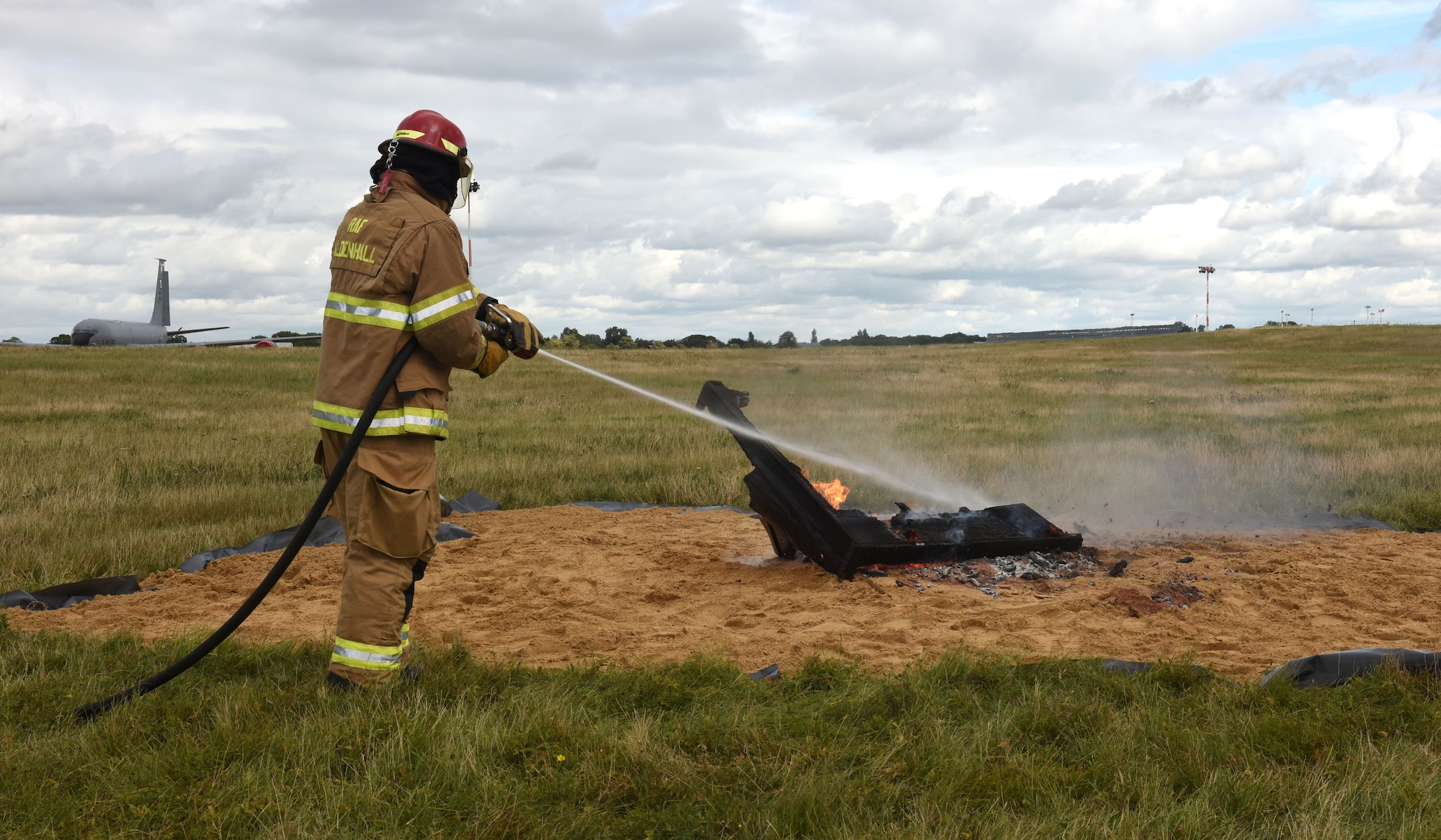 A firefighter from the 100th Civil Engineer Squadron Fire Department puts out the ashes of a burning piano at Royal Air Force Mildenhall, England, Oct. 1, 2021. The 100th Operations Group set fire to a piano as they followed a Royal Air Force World War II tradition to remember military members who paid the ultimate sacrifice. The event also marked the end of a successful flying and fiscal year for 2021, and the team’s hard work in Rockin’ ‘D’ Mish. (U.S. Air Force photo by Karen Abeyasekere)